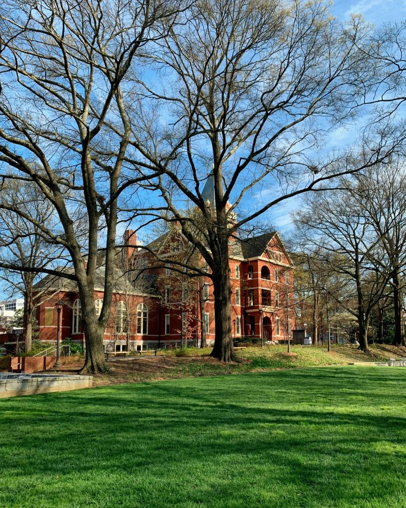 View of a historic red brick building surrounded by trees on a sunny day in Atlanta.